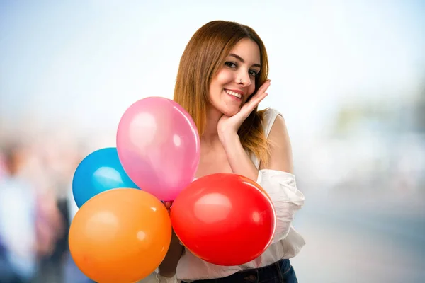 Ευτυχής όμορφη νεαρή κοπέλα κρατώντας ένα μπαλόνι σε αόριστες έκφραση — Φωτογραφία Αρχείου