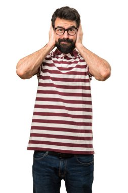 Kulakları kapsayan gözlüklü adam