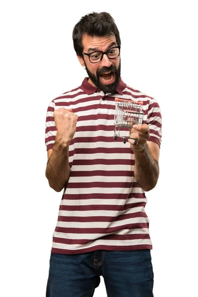 Uomo con gli occhiali in possesso di un giocattolo carrello del supermercato — Foto Stock