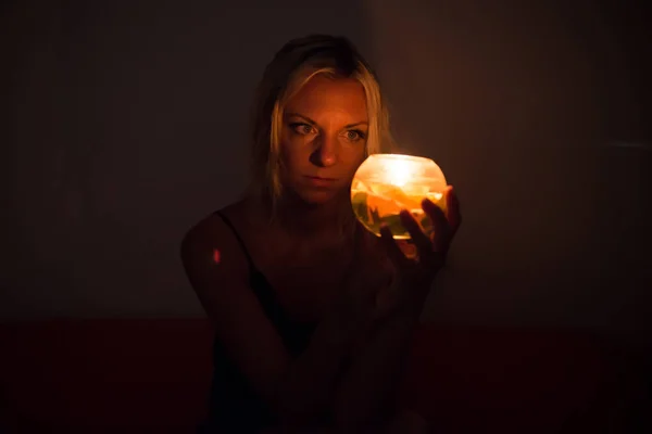 Дівчина всередині своєї кімнати вночі зі свічкою — стокове фото
