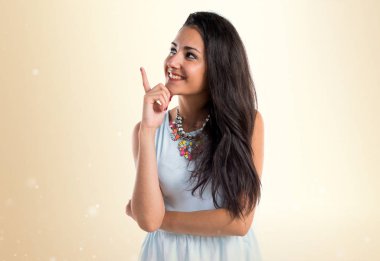 Koyu sarı arka plan üzerinde yukarıyı genç sevimli kız