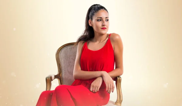 Vintage okra backgrou koltukta kırmızı elbise ile güzel kız — Stok fotoğraf