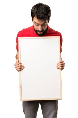 Boş bir afiş tutarak şaşırmış yakışıklı adam