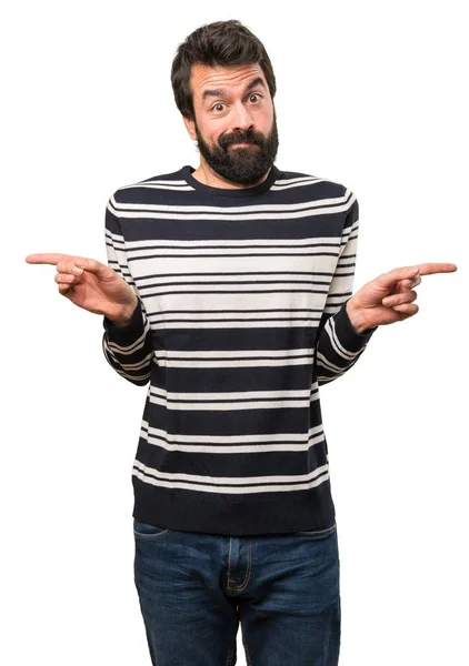Man with beard pointing to the laterals having doubts — Stock Photo, Image