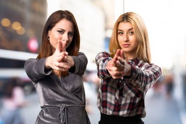 İki arkadaş silah jest yapmak odaklanmamış arka plan üzerinde