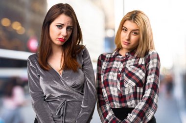 Üzgün iki arkadaş odaklanmamış arka plan üzerinde