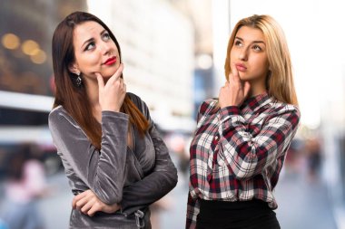 İki arkadaş odaklanmamış arka plan üzerinde düşünme