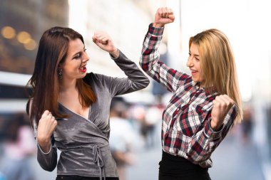 Şanslı iki arkadaş odaklanmamış arka plan üzerinde