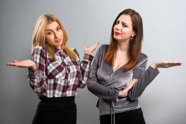 İki arkadaş dokulu arka plan üzerinde önemsiz jest yapma