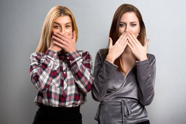 İki arkadaş dokulu arka plan onların ağızlarını kapsayan