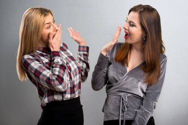 İki arkadaş sürpriz jest yapma dokulu arka plan