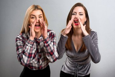 İki arkadaş dokulu arka plan üzerine bağırarak