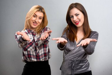 İki arkadaş bir şey dokulu arka plan üzerinde sunulması