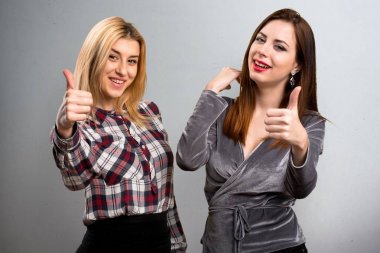 İki arkadaş dokulu arka plan üzerinde başparmak ile