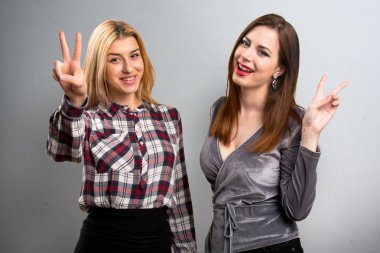 İki arkadaş zafer jest yapma dokulu arka plan