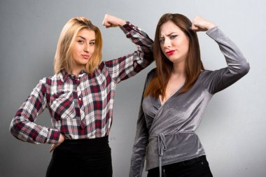 İki arkadaş dokulu arka plan üzerinde güçlü bir jest yapma