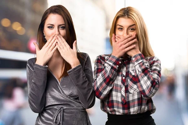 Two friends covering their mouths on unfocused background — Stock Photo, Image