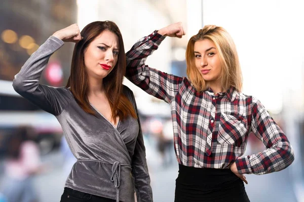 Two friends making strong gesture on unfocused background — Stock Photo, Image
