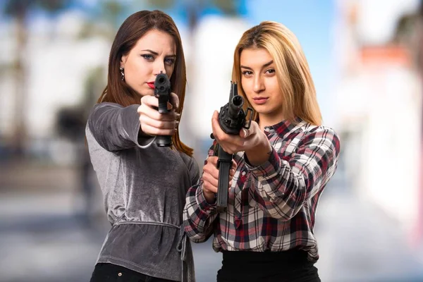 Dos amigos sosteniendo un rifle sobre fondo desenfocado — Foto de Stock