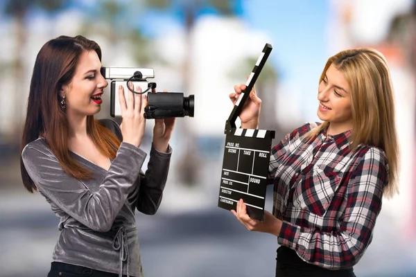 Dos amigos filmando sobre fondo desenfocado — Foto de Stock