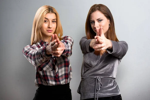 Dos amigos haciendo gesto de pistola sobre fondo texturizado —  Fotos de Stock