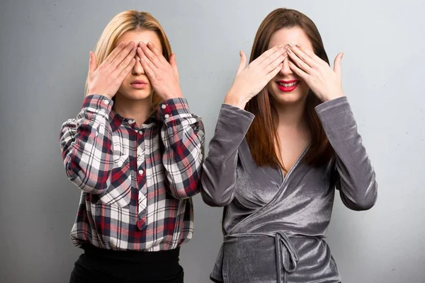 Dos amigos cubriendo sus ojos sobre fondo texturizado —  Fotos de Stock