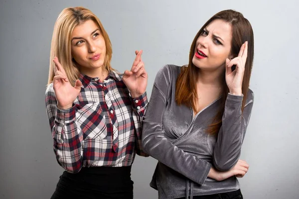 Deux amis avec leurs doigts croisés sur fond texturé — Photo