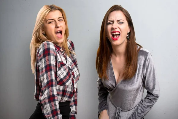 Two friends shouting on textured background — Stock Photo, Image