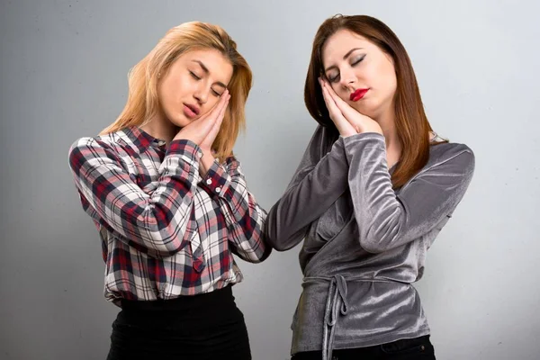 Due amici che fanno il gesto del sonno su sfondo strutturato — Foto Stock