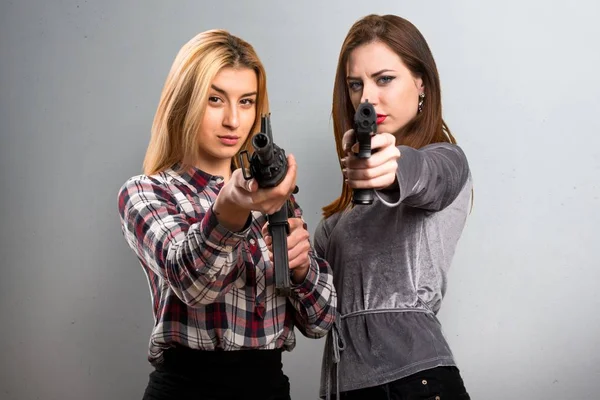 Dois amigos segurando uma espingarda no fundo texturizado — Fotografia de Stock