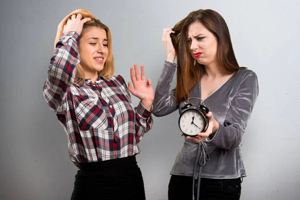 Dos amigos sosteniendo reloj vintage sobre fondo texturizado —  Fotos de Stock