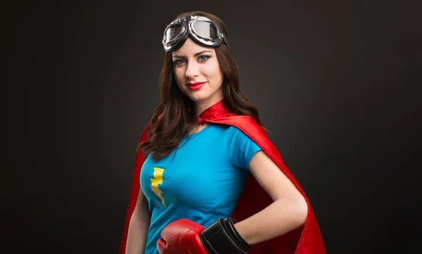 Bastante chica superhéroe con guantes de boxeo sobre fondo negro —  Fotos de Stock