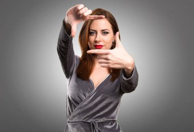 Güzel genç kız parmakları ile dokulu arka plan üzerinde duruluyor