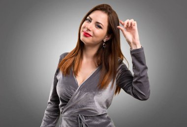 Güzel genç kız küçük işareti üzerinde dokulu arka plan yapma