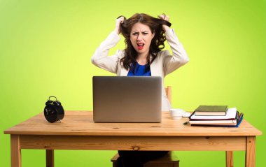 Onu laptop ile renkli ba üzerinde çalışan sinirli iş kadın