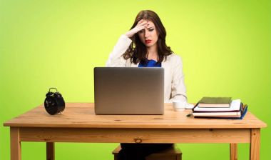 Onu laptop ile renkli ba üzerinde çalışan sinirli iş kadın