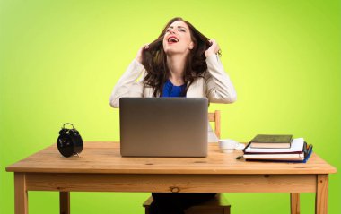 Onu laptop ile renkli ba üzerinde çalışan sinirli iş kadın