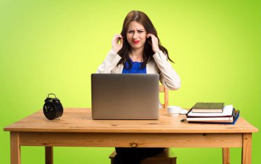 Onu laptop ile çalışma ve üzerinde kulakları kapsayan iş kadını 