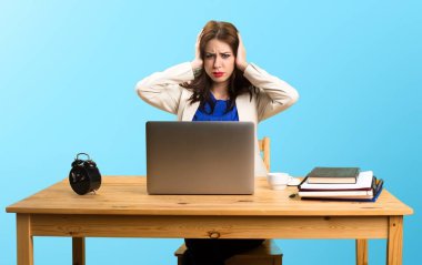 Onu laptop ile çalışma ve üzerinde kulakları kapsayan iş kadını 