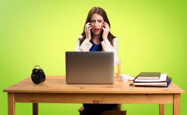 Onu laptop ile renkli ba üzerinde çalışan korkmuş iş kadın