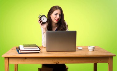 Onu laptop ile çalışma ve vintage saat tutan bir iş kadını