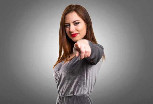 Hermosa joven apuntando al frente sobre fondo texturizado — Foto de Stock