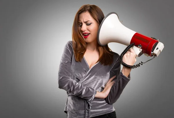 Mooi jong meisje een megafoon te houden op een gestructureerde achtergrond — Stockfoto