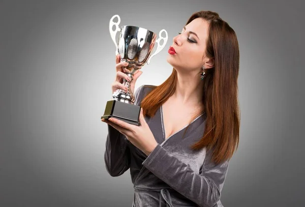 Bella ragazza in possesso di un trofeo su sfondo strutturato — Foto Stock