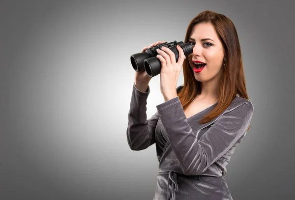 Krásná mladá dívka s dalekohledem na podklad s texturou — Stock fotografie