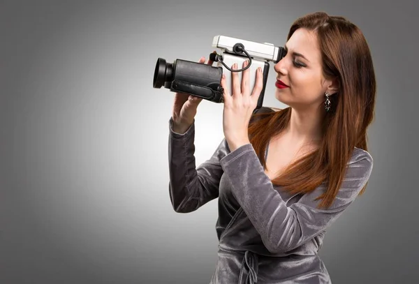 Schönes junges Mädchen filmt auf strukturiertem Hintergrund — Stockfoto