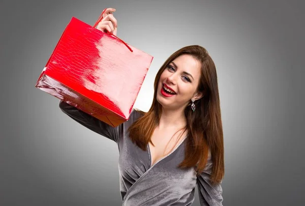 Menina bonita com saco de compras no fundo texturizado — Fotografia de Stock