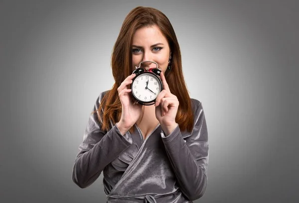 Hermosa joven sosteniendo reloj vintage sobre fondo texturizado —  Fotos de Stock