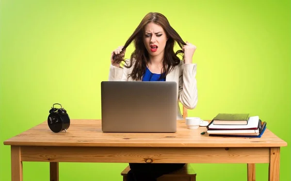 Frustrada mulher de negócios trabalhando com seu laptop em ba colorido — Fotografia de Stock