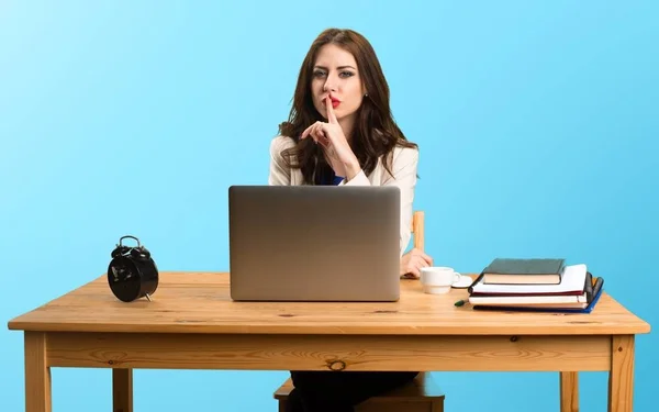 Деловая женщина работает со своим ноутбуком и делает жест молчания — стоковое фото